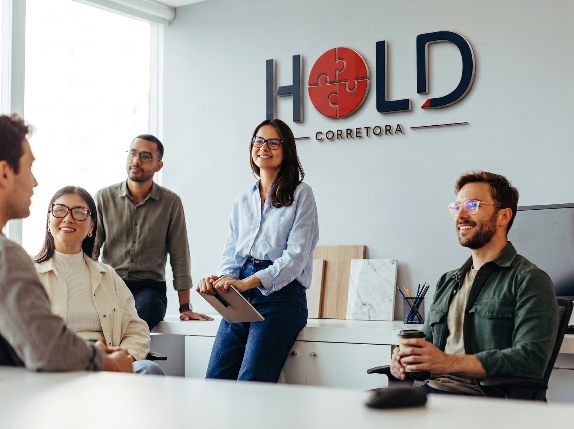 Hold Corretora — equipe em reunião estratégica no escritório